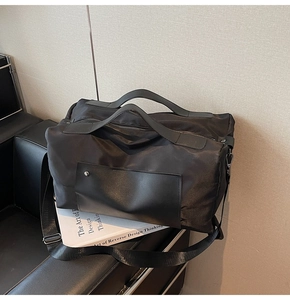 Close-up of large canvas travel bag with synthetic leather handles and metal hardware