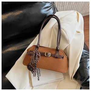 Detail of brown matte suede shoulder bag with gold buckle and fashion embossed lettering