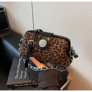 Close-up of leopard print crossbody bag featuring vintage metal buckle and silver chain strap
