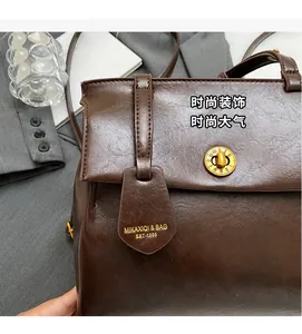 Detail of vintage brown leather backpack featuring a unique gold clock-style lock closure