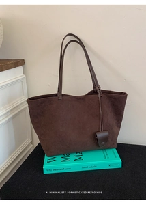 Dettaglio macro della borsa tote in pelle scamosciata marrone scuro dal design minimalista