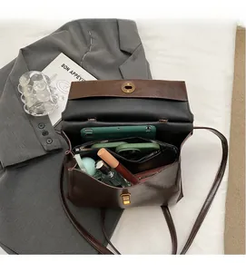 Detail showing spacious multi-compartment interior of vintage brown leather crossbody bag