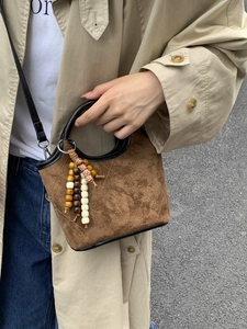 Sac seau en daim marron avec matelassage en losanges et pendentif en perles