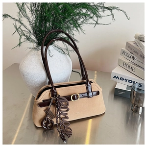 Detail of vintage camel suede shoulder bag with brown leather strap and gold pendants