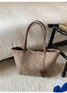 Dettaglio della grande borsa tote retrò in pelle scamosciata con manici caffè