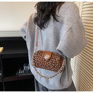 Detail of leopard print crossbody bag with silver chain strap and leather flap