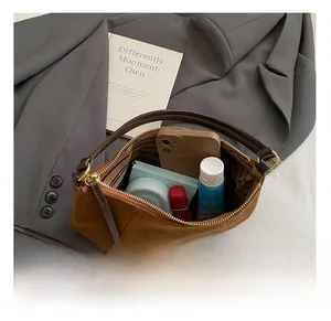 Interno della borsa in pelle scamosciata marrone con spazio per cellulare e trucchi