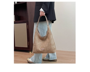 Close-up of brown suede tote bag featuring a minimalist leather label and large capacity