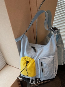 Borsa a tracolla in nylon azzurro con tasche gialle e ampia tracolla regolabile