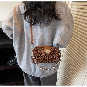 Chic leopard print crossbody bag with gold chain strap shown on a woman back view