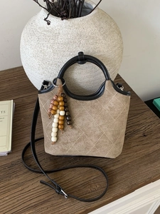 Sac seau vintage en daim kaki avec surpiqûres beiges et breloques en perles de bois
