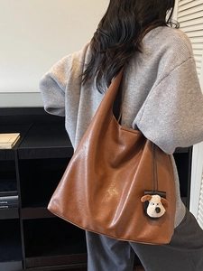 Retro brown leather tote bag for women with a cute plush dog charm on shoulder