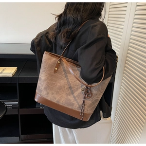 Close-up of a vintage brown tote bag with leather trim on a model for daily commute style