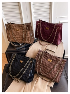 Close-up of quilted suede tote bags with gold chain straps in four elegant colors