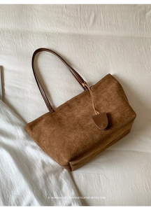 Dettaglio della texture in pelle scamosciata marrone scuro su una borsa tote retrò