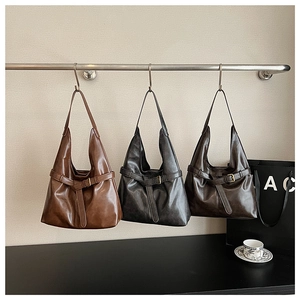 Three minimalist hobo tote bags in brown, grey, and coffee colors on a display stand