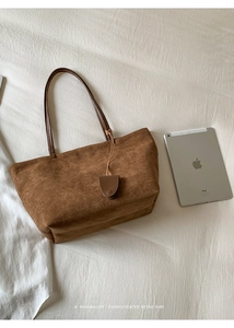 Borsa tote in pelle opaca marrone mostrata con un iPad per evidenziare la capienza