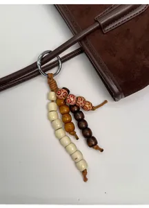 Detail of bohemian multicolored wooden bead bag charm with a silver spring clasp