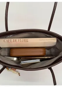 Interior view of brown tote bag showing large capacity for books and accessories