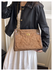 Detail of vintage brown suede tote bag with diamond quilting and gold twist lock