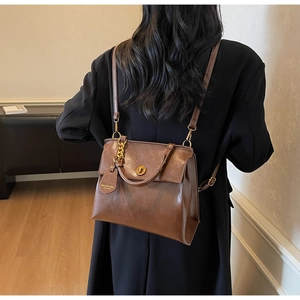 Close-up of vintage brown leather texture and elegant gold metallic twist lock detail