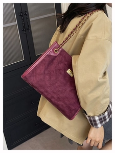 Détail du cabas en daim bordeaux avec motif matelassé et bandoulière dorée