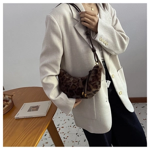 Détail du sac demi-lune en peluche léopard avec bandoulière en cuir et boucles dorées