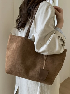 Borsa tote grande in camoscio marrone con spalline sottili e ciondolo ovale decorativo