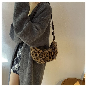 Détail d'un sac demi-lune en peluche léopard avec bandoulière en cuir à nœud élégant