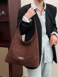 Minimalist deep brown faux suede tote bag worn by a model in a formal professional outfit