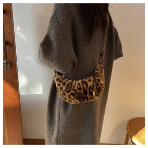 Détail du sac croissant en peluche léopard montrant la texture en fausse fourrure et l'anse