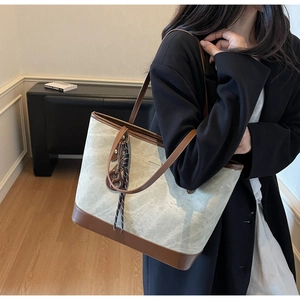 Detail of vintage tote bag with marble texture and brown leather strap on a model