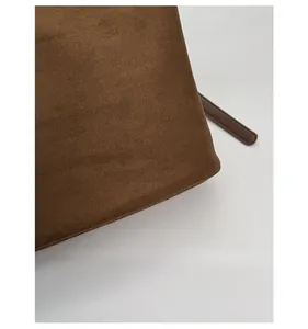 Close-up of caramel brown frosted suede texture and edge craftsmanship of bucket bag