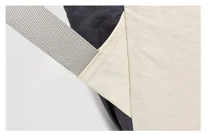 Detail of reinforced stitching on the black and beige outdoor backpack shoulder straps
