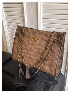 Détail du sac cabas en daim avec fermoir rotatif doré et bandoulière chaîne