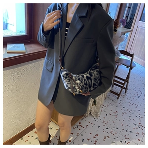 Détail du sac croissant en fausse fourrure léopard avec bandoulière réglable en cuir