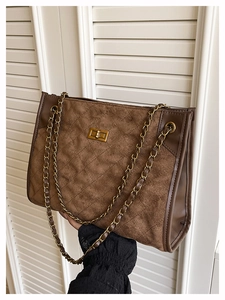 Détail du sac cabas en suédine matelassée marron avec chaîne dorée et fermoir rotatif