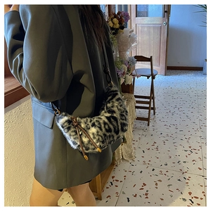 Détail du sac bandoulière en peluche léopard avec une fine lanière marron foncé