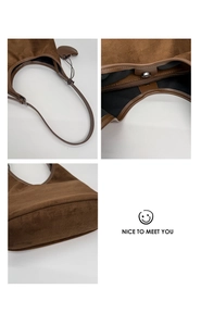 Detail of dark brown suede hobo bag featuring leather strap and secure zipper closure