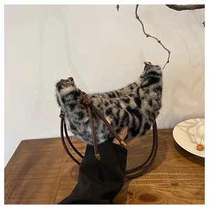 Détail du sac croissant en fausse fourrure léopard avec bandoulière en cuir et boucles