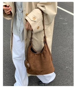 Deep brown suede hobo bag styled with a beige trench coat for a trendy autumn look