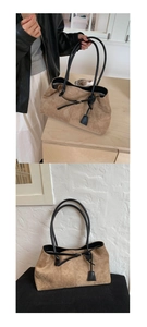 Dettaglio della borsa tote in pelle scamosciata marrone con sottili manici neri
