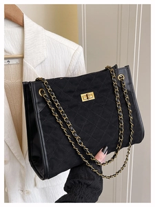 Détail du sac à bandoulière en daim matelassé noir avec fermoir doré et bandoulière chaîne