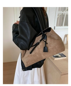 Vista dettagliata di una grande borsa tote in camoscio cammello con tracolle in pelle nera