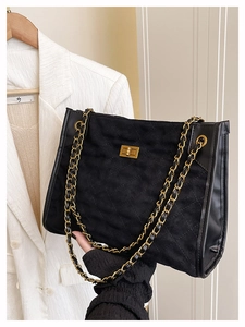 Détail du sac cabas en daim matelassé noir avec chaîne dorée et fermoir pivotant