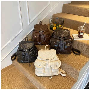 Retro faux leather backpacks in four colors displayed on stairs for daily commuting style