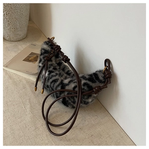 Détail du sac hobo en fausse fourrure léopard gris avec bandoulières en cuir marron