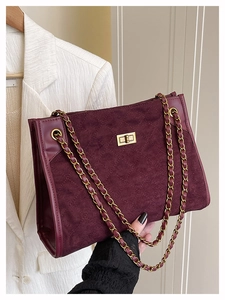 Détail du sac en suédine bordeaux avec motif matelassé et fermoir doré rotatif