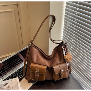 Dettaglio borsa Hobo scamosciata marrone scuro con tasche frontali e ciondolo orsetto