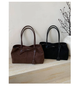 Dettaglio di borse tote vintage in pelle opaca marrone scuro e nero con coulisse decorativa